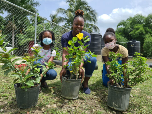 Landscaping supervisor at Sandals Negril, Neressa Haughton (center), was elated to pass on her gardening knowledge to Kendal Primary school students Tianna Brown (right) and Keitha Stewart (left), other students present on the day also assisted in paint work.