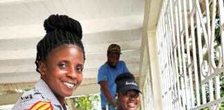 Sandals South Coast Volunteers, Vanessa Williams (foreground) and Evernie Taylor (background) paint the entrance gate at the Bluefields Police Station.