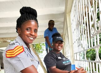 Sandals South Coast Volunteers, Vanessa Williams (foreground) and Evernie Taylor (background) paint the entrance gate at the Bluefields Police Station.