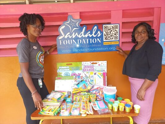 After handing over donations, Joy pauses to share lens time with a smiling Christene Dennis, Principal of the Windsor Basic School in Siloah, St Elizabeth.