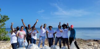 Members of the Public Relations and Earth Guardian teams from the Sandals Montego Bay region in a celebratory mood after conducting a beach clean-up in the adjacent White House community to mark World Oceans Day.