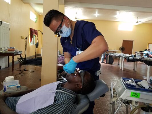 A Great Shape! Inc. volunteer dentist conducts a dental procedure at a 1000 Smiles Dental Clinic in 2019.