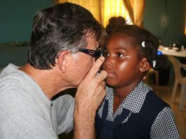 Great Shape! Inc. volunteer conducts an eye exam on a small child during an iCare clinic