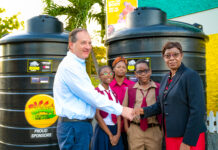 Wisynco’s Director of Marketing, Francois Chalifour (left) and Half Way Tree Primary School Principal Carol O’Connor Clarke (right), shake hands during the presentation of two 1,000 gallon water storage tanks to the institution on Thursday, January 19. The request from the institution’s Parent Teacher Association (PTA) was granted as part of Wisynco’s Bigga Soft Drink brand’s drive to support proper sanitation in schools which have a challenge with access to consistent running water. Looking on are Half Way Tree Primary School’s PTA 2nd VP, Tresha Hamilton Dunkley (centre); Head Girl, Erica Bernard (2nd from left) and Deputy Head Boy, Adjae McHugh (2nd from right).