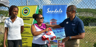 Sandals Montego Bay General manager Christopher Elliott handing over a set of netball bibs as part of his company’s sponsorship of the Flanker SDC Community Netball League to Tracy-Ann Davis of the organizing committee while Amalya Stewart looks on. Occasion was the Rally to mark the opening of the competition.