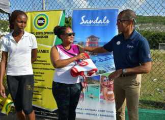 Sandals Montego Bay General manager Christopher Elliott handing over a set of netball bibs as part of his company’s sponsorship of the Flanker SDC Community Netball League to Tracy-Ann Davis of the organizing committee while Amalya Stewart looks on. Occasion was the Rally to mark the opening of the competition.