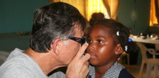 Great Shape! Inc. volunteer conducts an eye exam on a small child during an iCare clinic