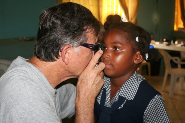 Great Shape! Inc. volunteer conducts an eye exam on a small child during an iCare clinic