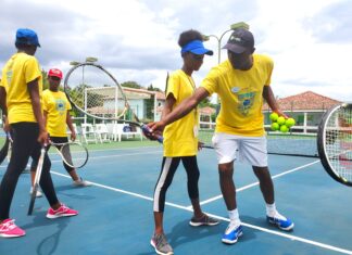 Tennis Pro, Norman Hall shows Khamiela Atlan how to correctly manoeuvre the racquet.