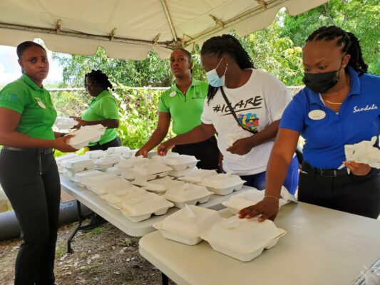 Volunteers from Sandals South Coast sort through warm lunches for the homeless during a World Homeless Day initiative at the Drop-in Centre in Black River.