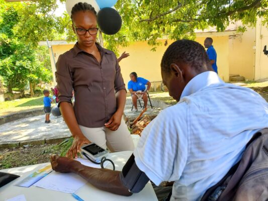 Shane Smyle, a Physiotherapist from the Board of Supervision in the Ministry of Local Government and Community  Development checks the blood pressure of a homeless man on World Homeless Day at the Drop-in Centre in Black River. 