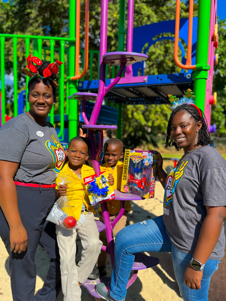 West End Infant students Raphael Salmon (second left) and Ajess Thompson (second right) shared they were excited to play with their toys gifted by Sandals Negril’s Monique Munroe (left) and Maxine Henry.