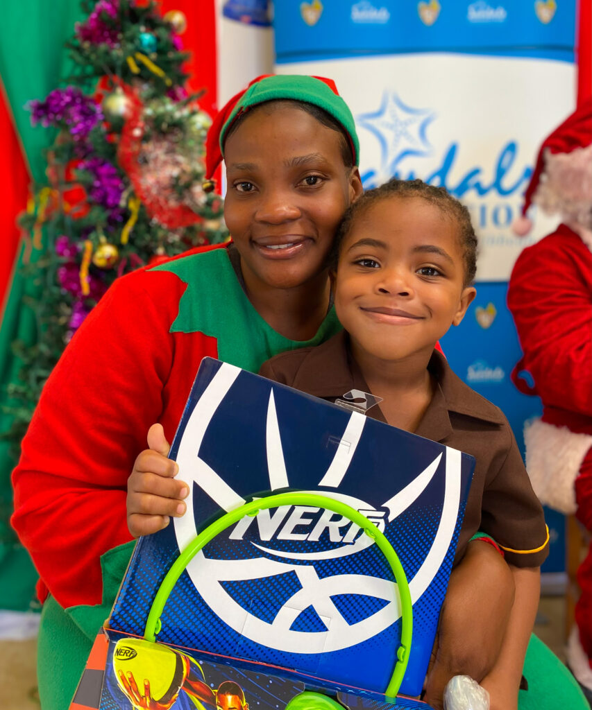 West End Infant students Raphael Salmon (second left) and Ajess Thompson (second right) shared they were excited to play with their toys gifted by Sandals Negril’s Monique Munroe (left) and Maxine Henry.