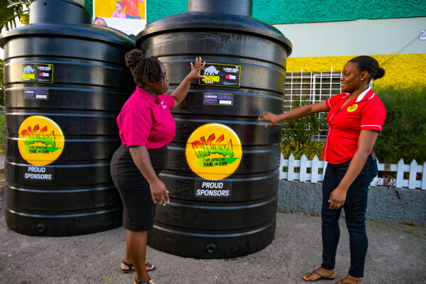 President of Half Way Tree Primary School’s Parent Teacher Association (PTA), Kelly-Ann Fraser (left) and Marketing Assistant at Wisynco, Peta-Gaye Peccoo (right) are pictured discussing the delivery of two 1,000 gallon storage tanks to the school on January 19. The request which came from the institution’s PTA was granted as part of Wisynco’s Bigga Soft Drink brand’s drive to support proper sanitation in schools which have a challenge with access to consistent running water.