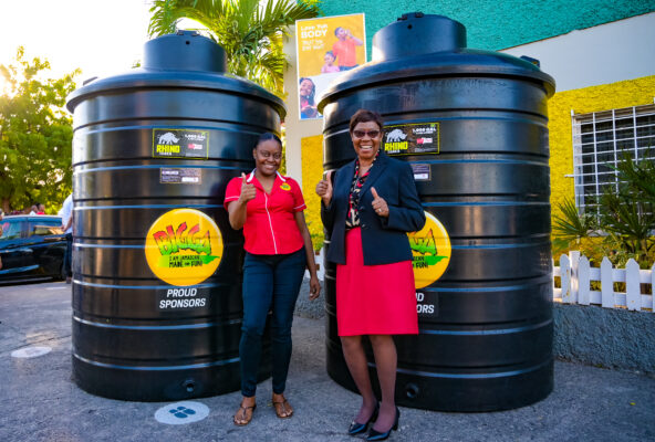 Peta-Gaye Peccoo, marketing assistant for Bigga Soft Drinks and Carol O’Connor Clarke, principal of Half Way Tree Primary School in Kingston give a thumbs up during the presentation of two 1,000 gallon water storage tanks from Wisynco to the institution on Thursday, January 19. The request from the institution’s Parent Teacher Association was granted as part of Bigga’s drive to support proper sanitation in schools which have a challenge with access to consistent running water.