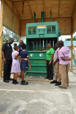 EHS Manager, Vilma Smith (3rd right) explains to students from the Kings Primary school Environmental club what items can be placed in the bailer unit at Sandals South Coast and how their school can participate in a waste separation project.